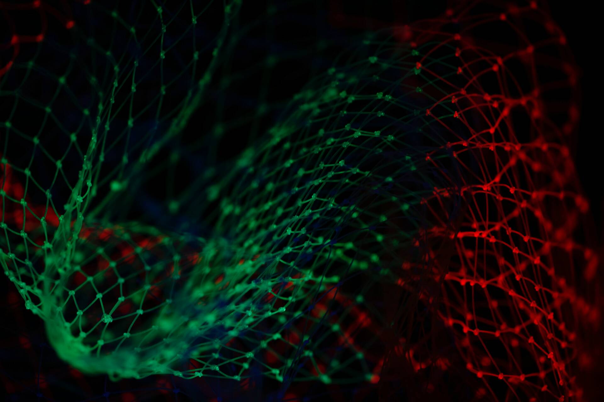 Close-up image of a net illuminated by green and red lights.